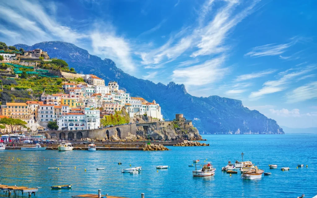 Beautiful Amalfi on hills leading down to coast, comfortable beaches and azure sea on Amalfi Coast in Campania, Italy
