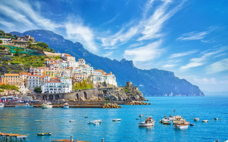 Beautiful Amalfi on hills leading down to coast, comfortable beaches and azure sea on Amalfi Coast in Campania, Italy