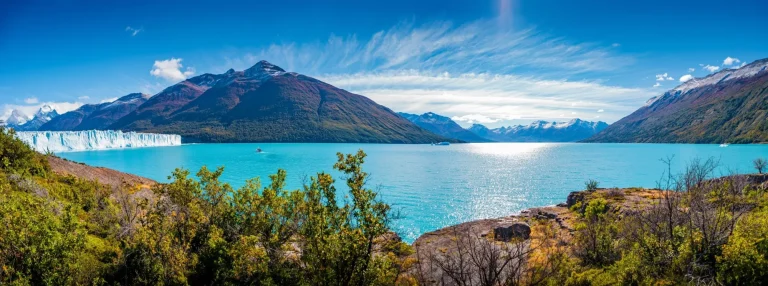 Panoramic view of the huge Perito Moreno glacier in Patagonia in golden Autumn, South America, sunny day, blue sky