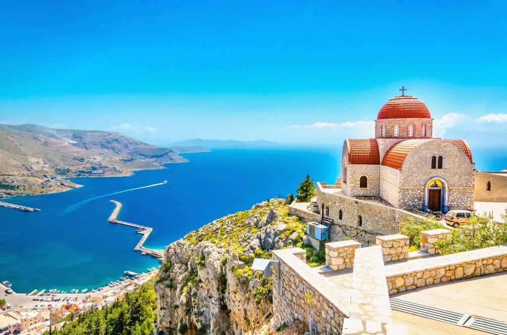 Remote church with red roofing on cliff, Greece